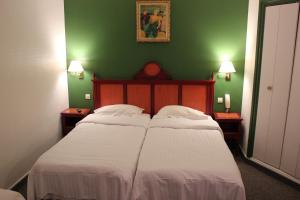 a bedroom with two beds and a green wall at Metropol in Paris