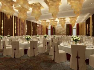 a banquet hall with white tables and white chairs at AOLUGUYA in Harbin