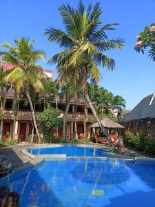 una piscina di fronte a un edificio con palme di Nyiur Resort Hotel a Pangandaran