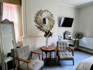 a room with a table and two chairs and a mirror at The Claremont in Woodhall Spa