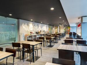 a restaurant with tables and chairs in a cafeteria at Amaris Hotel Padjajaran Bogor in Bogor