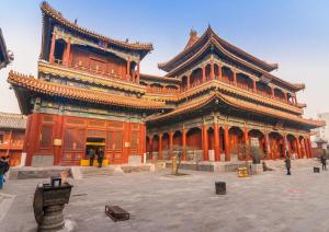a large orange building with a large building at Hanting Hotel Beijing National Stadium Branch in Beijing