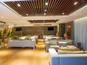 a lobby with white couches and tables at Iris Hotel Can Tho in Can Tho