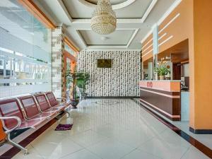 Un vestíbulo con una sala de espera con sillas y una lámpara de araña. en OYO 3157 Grand City Inn, en Pampang