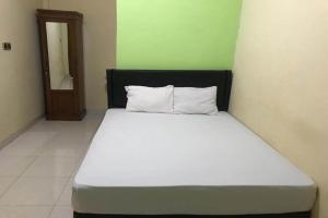 a bedroom with a large white bed in a room at Hotel O Penginapan Mc Lodge in Komodo Labuan Bajo Airport