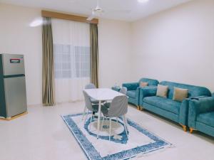 a living room with a blue couch and a table and chairs at أجاويد 2 Ajaweed in Salalah