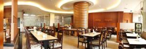a dining room with tables and chairs in a restaurant at Kedaton Hotel in Bandung