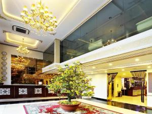 a lobby with a tree in the middle of a building at Golden Crown Hotel Saigon in Ho Chi Minh City