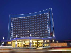a large hotel building with a lot of windows at Bliss International Hotel Weihai in Weihai