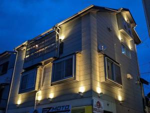 a building with lights on the side of it at Misato Guest House in Suita