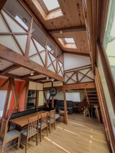 吹田市にあるMisato Guest Houseのテーブル、椅子、時計が備わる客室です。