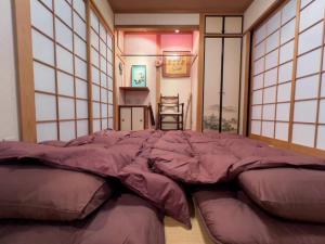 吹田市にあるMisato Guest Houseの大きな窓が備わる客室の大型ベッド1台分です。