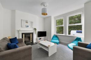 a living room with two couches and a fireplace at Park View House Close to Central Park and Plymouth Argyle FC - Dogs welcome - Hosted by Absolute Accommodation Plymouth in Plymouth