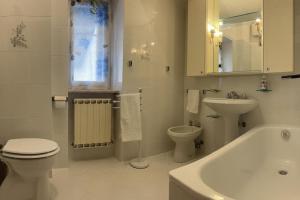 a white bathroom with a toilet and a sink at Meihome-Genova in Genova