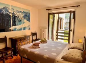 a bedroom with a bed and a desk and a window at Da Odette in Morgex