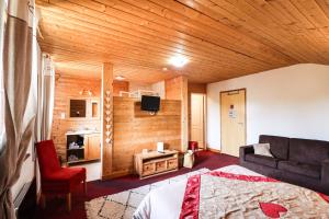 a room with a bed and a couch and a tv at Domaine de l'Adoux in Saint-Jean