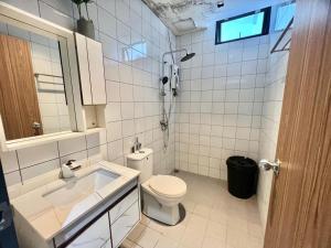 a white bathroom with a toilet and a sink at Homie 3 Rooms airconds with living hall aircond with pool and free wifi - 500meter from Hospital Sultanah Bahiyah Alor Setar Kedah in Kampong Masjid +39 photos