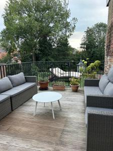 a patio with two couches and a coffee table at Loft room heerenhuys in Eeklo