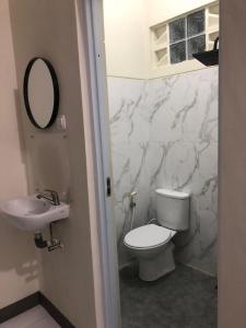 a bathroom with a white toilet and a sink at Bernice Homestay Syariah 1 Wonosobo in Wonosobo
