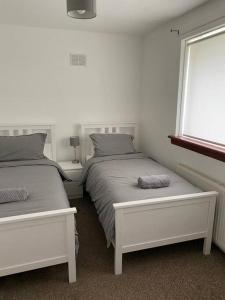 a bedroom with two beds and a window at 3 bedroom detached house, close to Glasgow in Barrhead