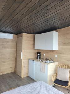 a kitchen with a sink and a chair in a room at Mökkilautta in Kalajoki