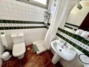 a bathroom with a white toilet and a sink at Sol & Mar in El Médano