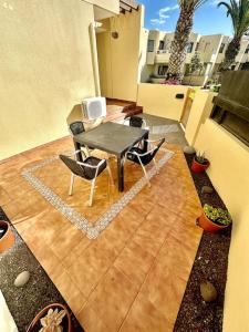 a patio with a table and chairs on a balcony at Sol & Mar in El Médano