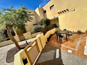 a balcony of a building with a table and a tree at Sol & Mar in El Médano