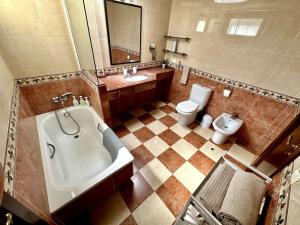 a large bathroom with a tub and a toilet at Sol & Mar in El Médano