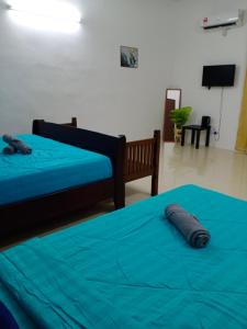 a bedroom with two beds with blue sheets and a television at ALOR SETAR SUPERIOR ROOM VISTANA INDAH GUESTHOUSE by Zenith Smart in Alor Setar +13 photos