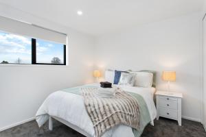 a white bedroom with a bed and a window at Prime Location Cosy Warm Free Off Street Park in Addington