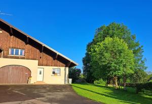 a barn with a tree in front of it at Maison La Roche du Miroir in Plaimbois-du Miroir