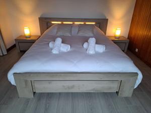 a bed with three pillows and two lights on it at Maison La Roche du Miroir in Plaimbois-du Miroir
