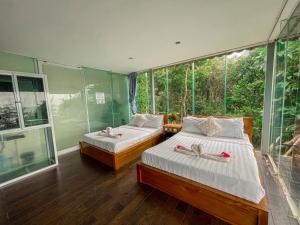two beds in a room with a large window at Ocean Lounge Bungalow in Koh Rong +35 photos