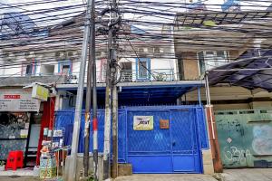 a blue gate in front of a building with graffiti at Wisma Ibu Indri in Jakarta