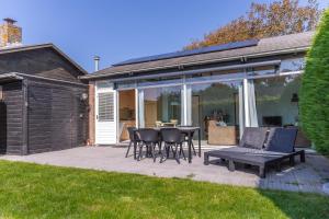 a patio with a table and chairs and a bench at Boerenslag 24 in Sint Maartensvlotbrug