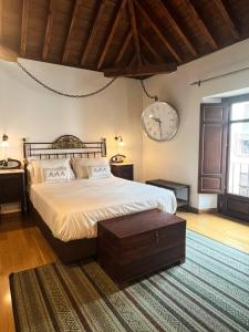 a bedroom with a large bed and a clock on the wall at Gar Anat Hotel Boutique in Granada