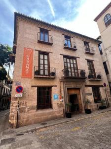 a brick building with windows and balconies on a street at Gar Anat Hotel Boutique in Granada