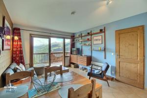 a living room with a couch and a table at Sainte-Foy Station, Appartement 2 chambres rénové, Vue vallée, Skis aux pieds in Sainte-Foy-Tarentaise