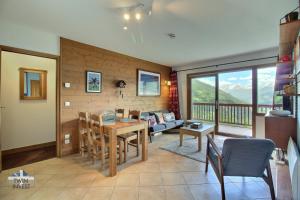 a living room with a table and a couch at Sainte-Foy Station, Appartement 2 chambres rénové, Vue vallée, Skis aux pieds in Sainte-Foy-Tarentaise