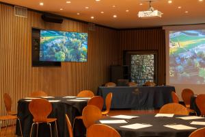 a conference room with tables and a projection screen at Borgo San Luigi in Monteriggioni +37 photos