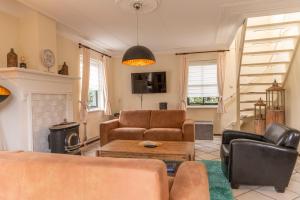 una sala de estar con un sofá y una mesa en Buitenplaats 67, en Callantsoog