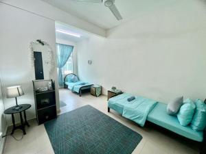 a living room with a blue couch in a room at Comel House Hadapan Hospital Sultanah Bahiyah Alor Setar- Teres 2 Tingkat Vistana Indah Depan HSB 4 Bilik Airconds & Ruang tamu aircond dan free wifi in Kampong Masjid