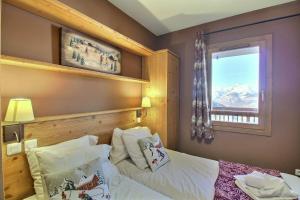 a bedroom with a bed and a window with mountains at Sainte-Foy Station, Appartement 2 chambres rénové, Vue vallée, Skis aux pieds in Sainte-Foy-Tarentaise