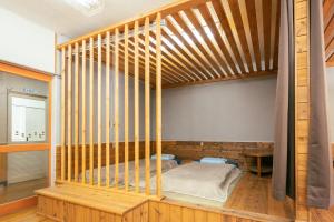 a bedroom with a bed in a wooden room at まるもりビレッジ in Wada
