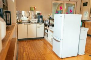 a kitchen with a white refrigerator and a wooden floor at まるもりビレッジ in Wada +26 photos