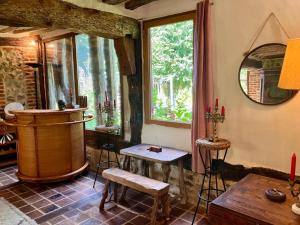 a living room with a table and a window at La maison normande 5 chambres in Anciens