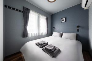 a bedroom with a bed with towels on it at The Serenity in Nishi-nijō