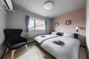 a hotel room with a bed and a chair at The Serenity in Obihiro