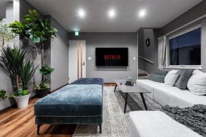 a living room with a couch and a tv at The Serenity in Nishi-nijō